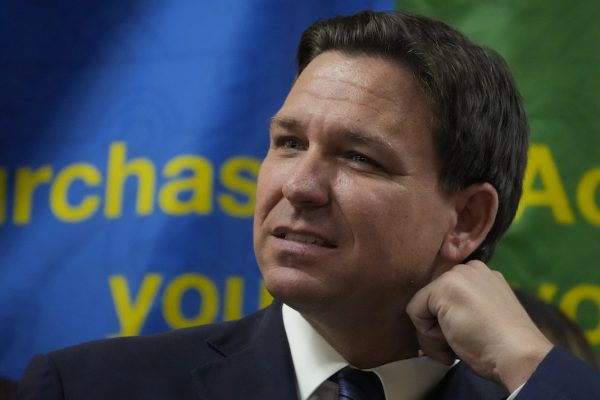 FL Gov. Ron DeSantis adjusts his collar during a press conference announcing expanded toll relief for Florida commuters, Wednesday, Sept. 7, 2022, in Miami, Fla. - AP Photo/Rebecca Blackwell via The American Independent
